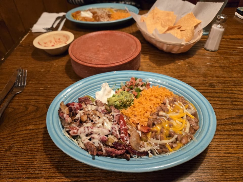 Plates of burritos, enchiladas, and salsa.